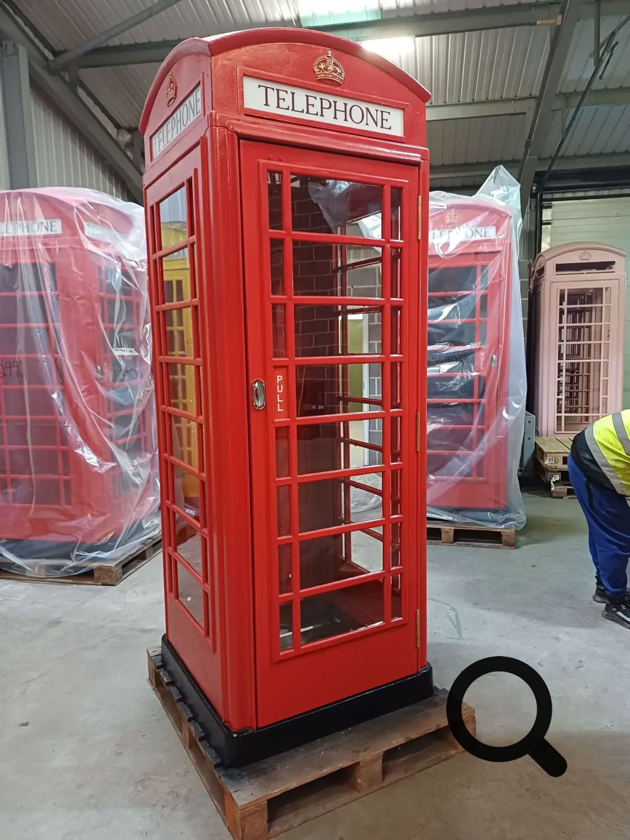 Red telephone box door way with open door in an interior.
