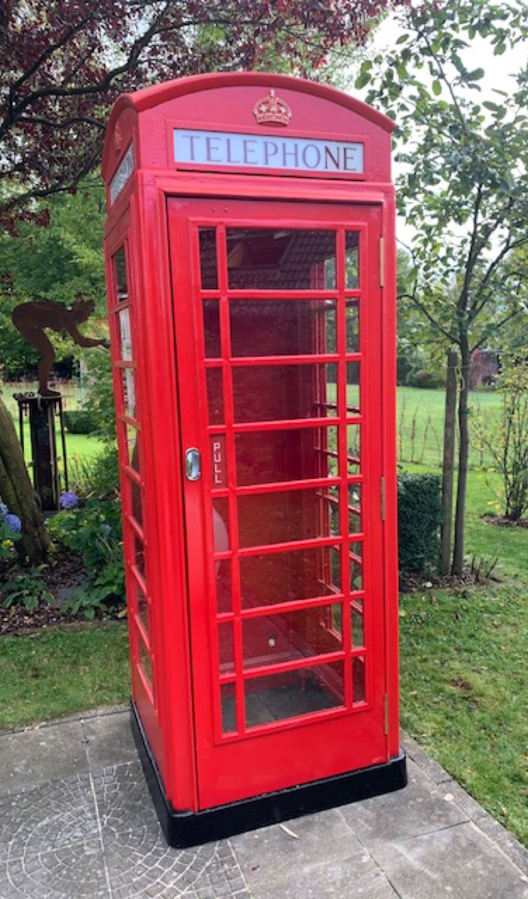 Restored red K6 telephone box in a garden in Belgium